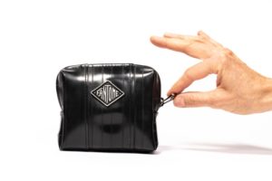 Trousse noir avec une main à la jpo qui ouvre la fermeture éclair